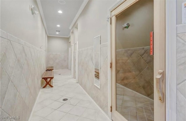 bathroom with ornamental molding, tile patterned flooring, and tile walls