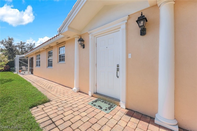 view of exterior entry with a patio area