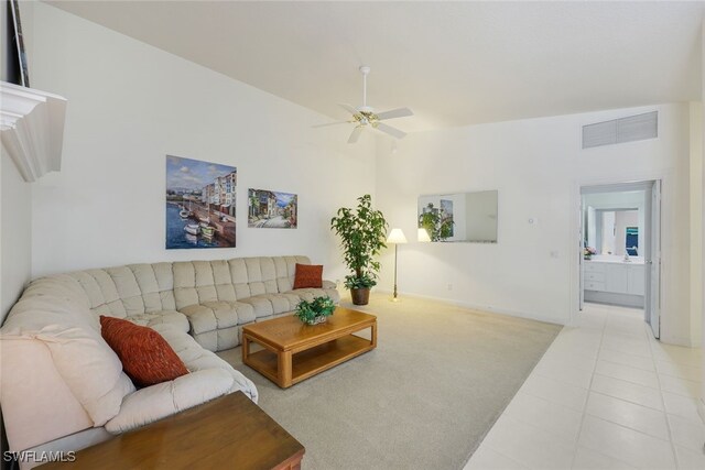 living room featuring lofted ceiling, light tile patterned floors, and ceiling fan