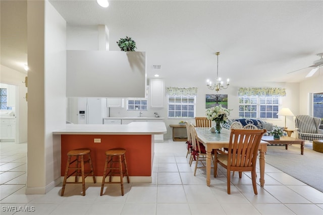 dining room featuring light tile patterned floors, ceiling fan with notable chandelier, and sink