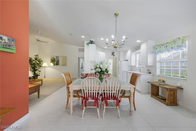 tiled dining area with lofted ceiling and ceiling fan with notable chandelier