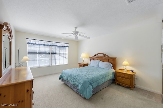 bedroom with light carpet, a textured ceiling, and ceiling fan