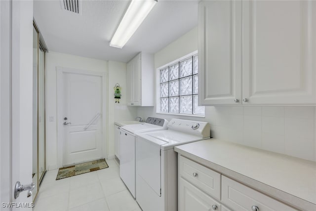 laundry area with independent washer and dryer and cabinets