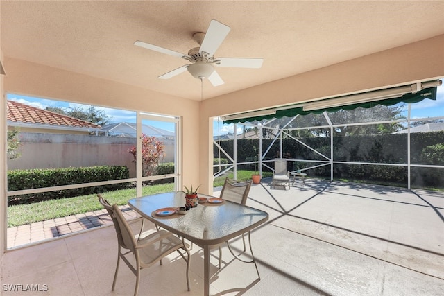 unfurnished sunroom with ceiling fan