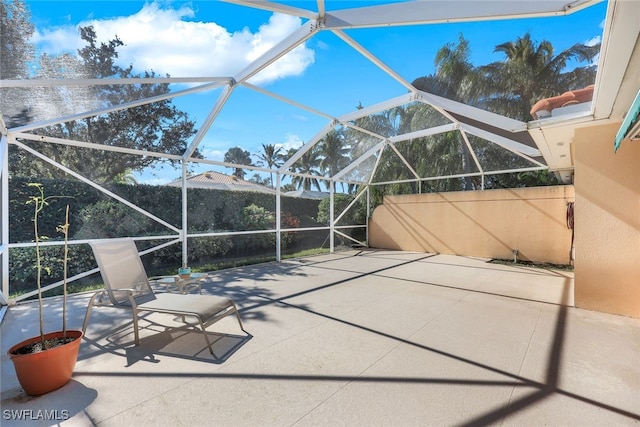 view of patio featuring glass enclosure