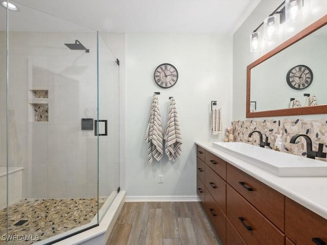 bathroom with vanity, backsplash, wood-type flooring, and walk in shower