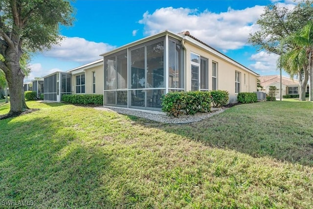 view of home's exterior with central AC unit, a lawn, and a sunroom