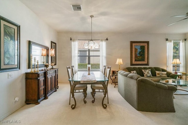 dining area with light carpet and ceiling fan