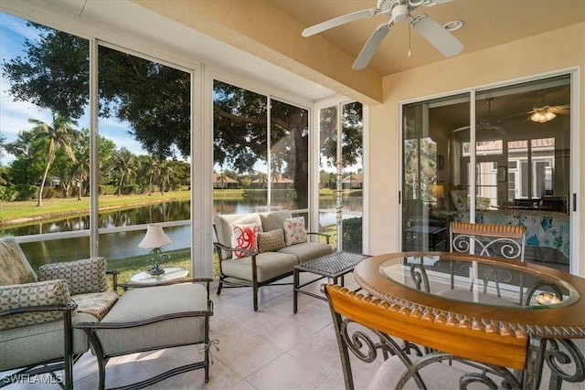 sunroom featuring ceiling fan and a water view