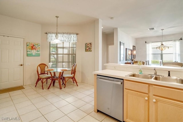 kitchen with pendant lighting, light brown cabinetry, stainless steel dishwasher, light tile patterned floors, and an inviting chandelier