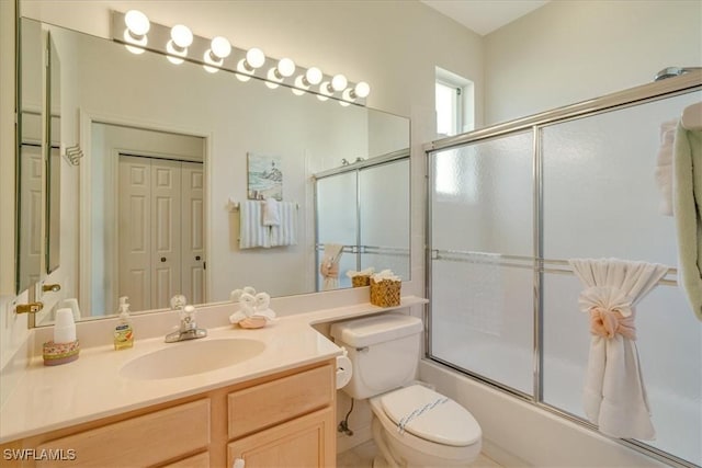 full bathroom with vanity, shower / bath combination with glass door, and toilet