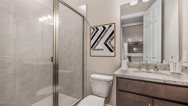 bathroom featuring toilet, a shower stall, and vanity