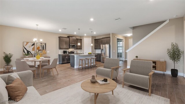 living room with light hardwood / wood-style floors and a chandelier