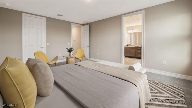 bedroom featuring carpet, ensuite bath, visible vents, and baseboards