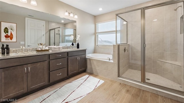 full bath featuring double vanity, a shower stall, and a sink