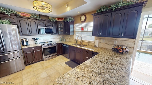 kitchen featuring plenty of natural light, stainless steel appliances, sink, and backsplash