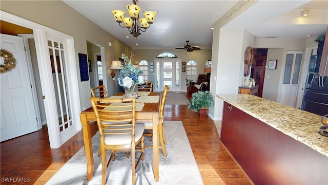 dining space with ceiling fan with notable chandelier, ornamental molding, and hardwood / wood-style floors