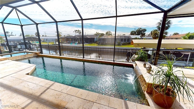 view of pool featuring an in ground hot tub, pool water feature, a water view, and glass enclosure