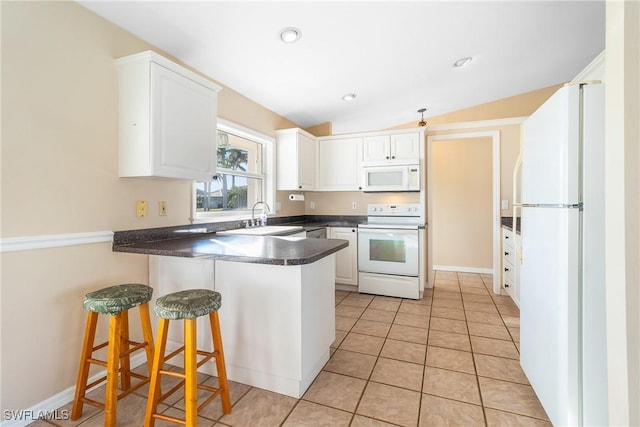 kitchen featuring sink, white appliances, white cabinets, a kitchen bar, and kitchen peninsula