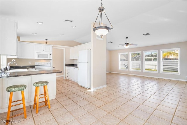 kitchen with sink, vaulted ceiling, light tile patterned floors, white appliances, and white cabinets