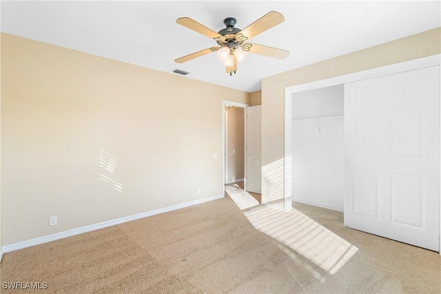 unfurnished bedroom featuring ceiling fan, light carpet, and a closet