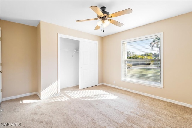 unfurnished bedroom featuring light carpet, a closet, and ceiling fan