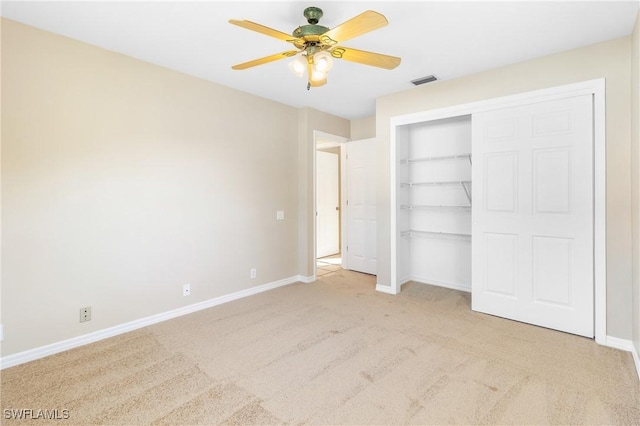 unfurnished bedroom featuring light carpet, a closet, and ceiling fan