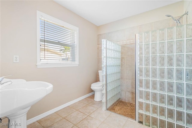 bathroom with sink, a tile shower, tile patterned floors, and toilet