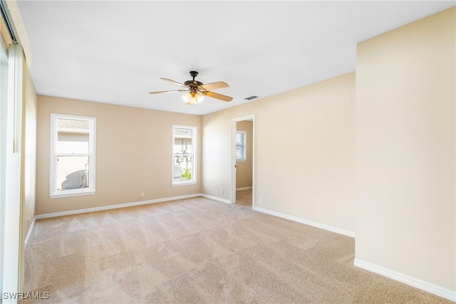 empty room with ceiling fan and light carpet