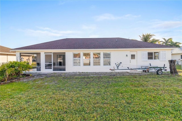 back of property featuring a yard and a sunroom