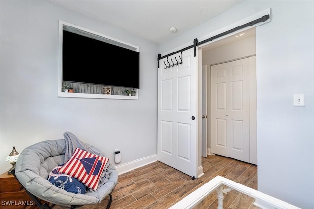 sitting room with hardwood / wood-style flooring and a barn door