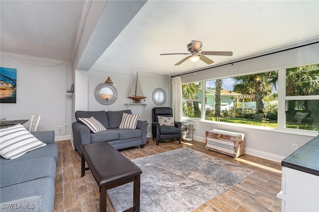 living room featuring hardwood / wood-style floors, crown molding, and ceiling fan