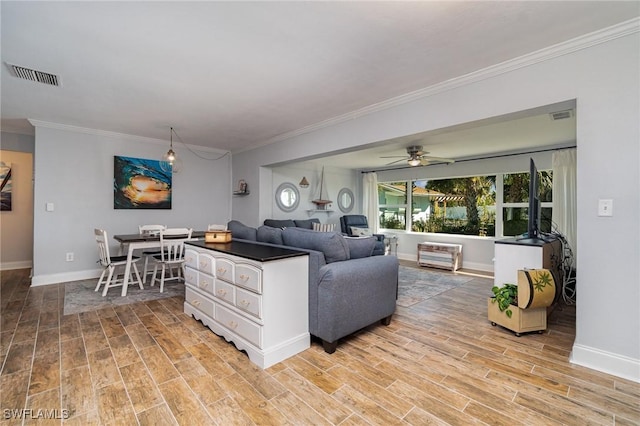 living room with crown molding, ceiling fan, and light wood-type flooring