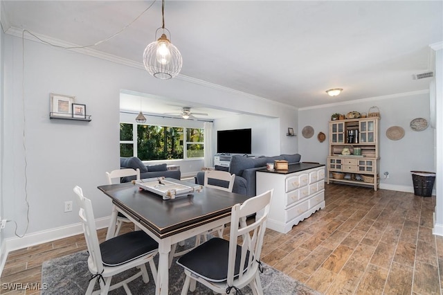 dining space with crown molding, wood-type flooring, and ceiling fan