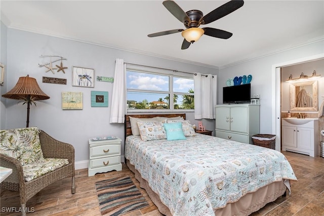 bedroom with sink, crown molding, wood-type flooring, and ensuite bathroom