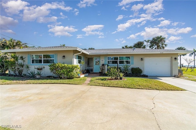 single story home with a garage and a front lawn