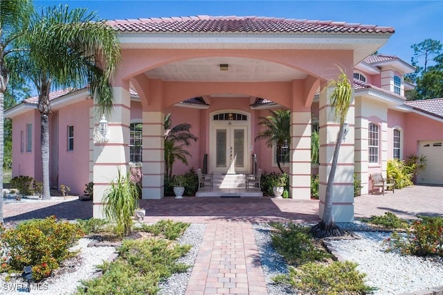 doorway to property featuring a garage and french doors