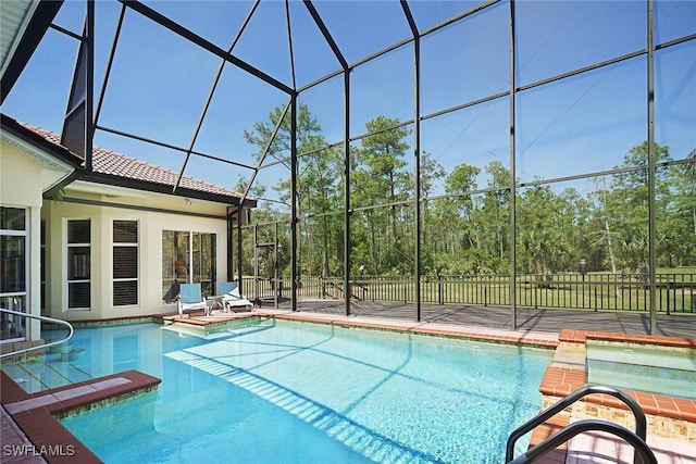 view of swimming pool featuring an in ground hot tub and a lanai