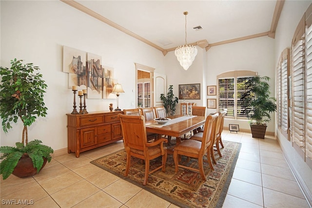 tiled dining area featuring a notable chandelier and ornamental molding