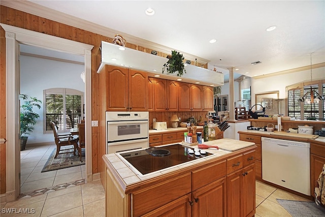 kitchen with pendant lighting, white appliances, tile countertops, and light tile patterned flooring