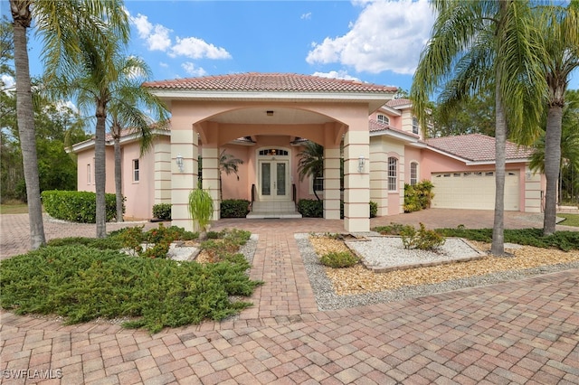 mediterranean / spanish house featuring a garage and french doors