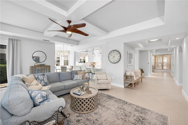 tiled living room with plenty of natural light, coffered ceiling, and ceiling fan with notable chandelier