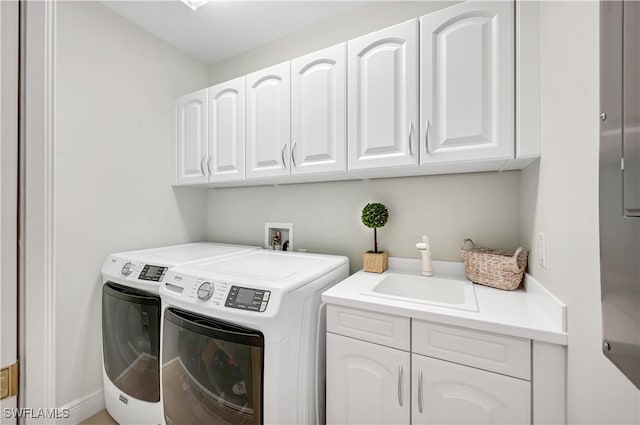 laundry room featuring sink, washing machine and dryer, and cabinets