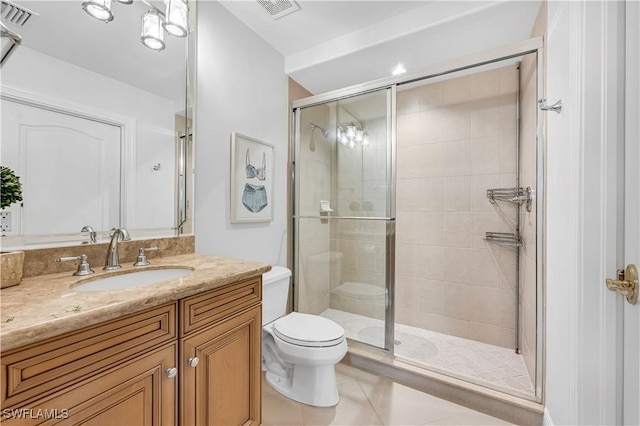 bathroom featuring walk in shower, vanity, toilet, and tile patterned flooring