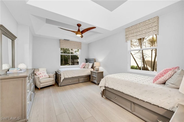 bedroom with multiple windows, ceiling fan, and light hardwood / wood-style flooring