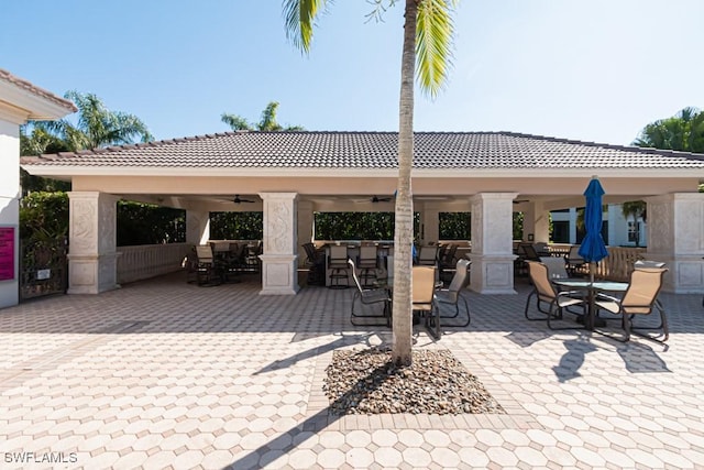 view of patio featuring a gazebo, ceiling fan, and exterior bar