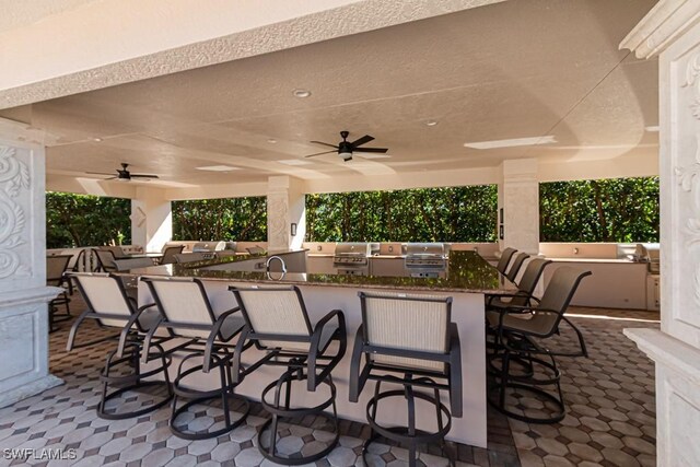 view of patio featuring area for grilling, a bar, and ceiling fan