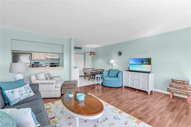 living area featuring visible vents and wood finished floors