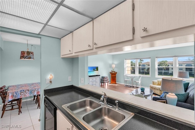 kitchen featuring dishwasher, sink, a paneled ceiling, and light tile patterned flooring