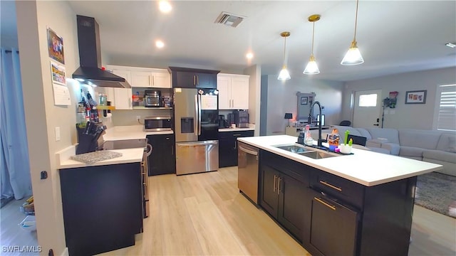 kitchen with stainless steel appliances, light countertops, open floor plan, a sink, and extractor fan